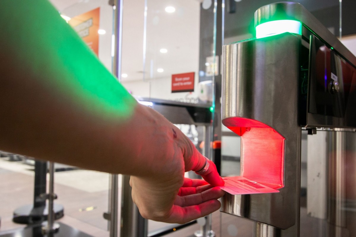 Someone scanning a card in an access control gate scanner