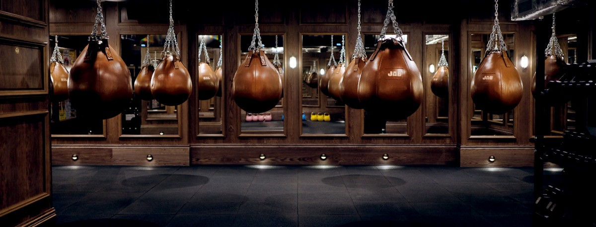 A row of JAB branded brown boxing bags in a mirrored boxing studio
